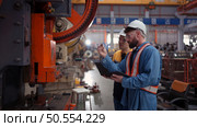 Engineer and technician discussing machinery in factory to plan inspection maintenance according to usage cycle, Concepts inspections based on usage cycle maintenance. Стоковое фото, агентство Ingram Publishing / Фотобанк Лори