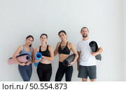 A group of female and male athletes stood and chatted amicably in the studio before beginning with the yoga class. Стоковое фото, агентство Ingram Publishing / Фотобанк Лори