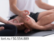 Young couple meditating in lotus pose on exercise mat at home, Yoga exercise concept. Стоковое фото, агентство Ingram Publishing / Фотобанк Лори