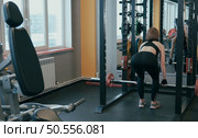 A girl training with a simulator sitting her back to the camera. . Стоковое фото, агентство Ingram Publishing / Фотобанк Лори