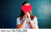 girl with obscure face and empty paper cut heart card isolated on blue. Стоковое фото, агентство Ingram Publishing / Фотобанк Лори