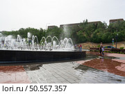 Высокие струи воды в фонтане на берегу реки Волги, счастливый дети возле фонтана в жаркий день. Волгоград, Центральная набережная, Россия. Редакционное фото, фотограф Андрей Цыганков / Фотобанк Лори