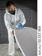 Surfboard manufacturing, Shaper working on board details. Concept of industrial manufacturing, qualified professional, occupation and employment. Стоковое фото, агентство Ingram Publishing / Фотобанк Лори