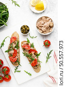 Tuna caper toasts with arugula, tomatoes and whole rye bread, top view. Стоковое фото, агентство Ingram Publishing / Фотобанк Лори