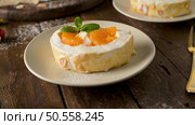Meringue roll cake with cream and tangerine. Roulade, summer dessert served in ceramic plate. Стоковое фото, агентство Ingram Publishing / Фотобанк Лори
