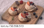Small pavlova cakes with fresh Strawberries and blueberries. Стоковое фото, агентство Ingram Publishing / Фотобанк Лори