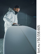 Surfboard manufacturing, Shaper working on board details. Concept of industrial manufacturing, qualified professional, occupation and employment. Стоковое фото, агентство Ingram Publishing / Фотобанк Лори