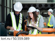 Group of engineers and technicians working together in a robotic arm factory. Inspecting robot arm before delivering to customers. Стоковое фото, агентство Ingram Publishing / Фотобанк Лори