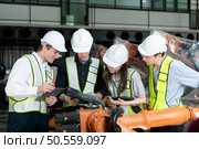 Group of engineers and technicians working together in a robotic arm factory. Inspecting robot arm before delivering to customers. Стоковое фото, агентство Ingram Publishing / Фотобанк Лори