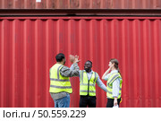 Group of workers in a container storage yard greeting each other during breaks in front of container warehouse, Стоковое фото, агентство Ingram Publishing / Фотобанк Лори