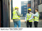 Group of workers in a container storage yard greeting each other during breaks in front of container warehouse, Стоковое фото, агентство Ingram Publishing / Фотобанк Лори