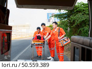 The paramedic  is assisting an injured man in an emergency situation on the road. Стоковое фото, агентство Ingram Publishing / Фотобанк Лори