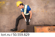 Young man working in a steel industry factory. He was critically hurt when a forklift ran over his leg and had to be transported to the hospital. Стоковое фото, агентство Ingram Publishing / Фотобанк Лори