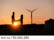 Silhouette of Engineer in charge of wind energy against a background of wind turbines. Стоковое фото, агентство Ingram Publishing / Фотобанк Лори