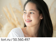 Portrait of a young asian woman with braces on her teeth. Стоковое фото, агентство Ingram Publishing / Фотобанк Лори