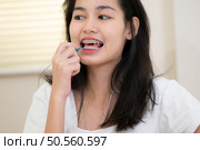 Portrait of a young asian woman with braces on her teeth. Стоковое фото, агентство Ingram Publishing / Фотобанк Лори