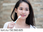 Portrait of a young asian woman with braces on her teeth. Стоковое фото, агентство Ingram Publishing / Фотобанк Лори