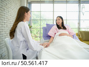 Female doctor with IV equipment will give IV fluids and examine patients lying in hospital beds. Стоковое фото, агентство Ingram Publishing / Фотобанк Лори