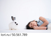 Smiling little girl and with their beloved fluffy rabbit, showcasing the beauty of friendship between humans and animals. Стоковое фото, агентство Ingram Publishing / Фотобанк Лори