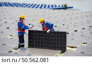 Photovoltaic engineers work on floating photovoltaics. Inspect and repair the solar panel equipment floating on the water. Стоковое фото, агентство Ingram Publishing / Фотобанк Лори