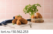 Cod dumplings, or "bolinhos de bacalhau" and parsley leaves on white ceramic dishes in a kitchen counter top. Стоковое фото, агентство Ingram Publishing / Фотобанк Лори