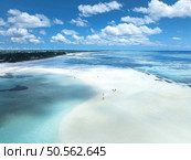 Aerial view of island during low tide, sandbank in ocean, white sandy beach, people, blue sea at sunny summer day in Zanzibar. Top view of sand spit, clear water, sky with clouds. Tropical background. Стоковое фото, агентство Ingram Publishing / Фотобанк Лори