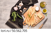 Fresh baked homemade grissini bread sticks in vintage metal grid box with olive oil and rosemary herbs over kitchen counter top. Стоковое фото, агентство Ingram Publishing / Фотобанк Лори
