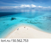 Aerial view of Nakupenda island, sandbank in ocean, white sandy beach, blue sea in low tide at sunny summer day in Zanzibar. Top view of sand spit, clear azure water, people, sky with clouds. Tropical. Стоковое фото, агентство Ingram Publishing / Фотобанк Лори