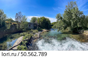 Rushing river Ancora in Portugal, with rapids flows past an old stone house nestled amongst lush greenery. Стоковое фото, агентство Ingram Publishing / Фотобанк Лори