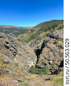 A serene valley with a wooden path, embraced by rocky cliffs. Guarda, Portugal. Стоковое фото, агентство Ingram Publishing / Фотобанк Лори