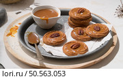Caramel cookies with pecan nuts served on roud plates, in the kitchen after baking. Стоковое фото, агентство Ingram Publishing / Фотобанк Лори