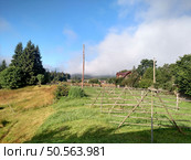 View of Hoverla Mountain in the Carpathians from the countryside grows green grass and a design for drying grass horizontal. Стоковое фото, агентство Ingram Publishing / Фотобанк Лори