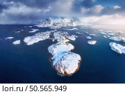 Aerial view of snowy Henningsvaer fishing village, Lofoten islands, Norway in winter at sunset. Top drone view of mountains in snow, sea, boats, cloudy sky, town, rorbuer and houses. Panorama. Scenery. Стоковое фото, агентство Ingram Publishing / Фотобанк Лори