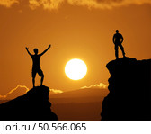 Man on top of mountain during and big sun. Silhouette of person in nature. Стоковое фото, агентство Ingram Publishing / Фотобанк Лори