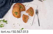 Meat patties and parsley leaves on white ceramic dishes in a kitchen counter top. Стоковое фото, агентство Ingram Publishing / Фотобанк Лори