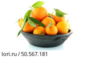 Tangerines on clay bowl isolated on white background. Стоковое фото, агентство Ingram Publishing / Фотобанк Лори