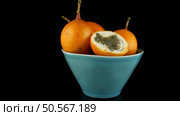 Passion fruit maracuja granadilla on ceramic blue bowl, black background. Стоковое фото, агентство Ingram Publishing / Фотобанк Лори