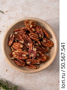 A bowl of pecans on a light-colored surface, showcasing the rich texture and color of the nuts, perfect for culinary use or snacking. Стоковое фото, агентство Ingram Publishing / Фотобанк Лори