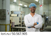 Portrait of production control supervisor inspects and controls the operation of each step in the production line of a canned fish factory. Стоковое фото, агентство Ingram Publishing / Фотобанк Лори