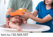 Parents bathe little child after ate meal. Стоковое фото, агентство Ingram Publishing / Фотобанк Лори
