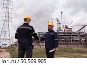 Both of Petroleum engineer is on a mission to inspect oil distillation at a huge oil refinery. Стоковое фото, агентство Ingram Publishing / Фотобанк Лори