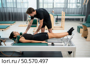 A young man and a young woman are doing pilates exercises on a pilates reformer. Стоковое фото, агентство Ingram Publishing / Фотобанк Лори