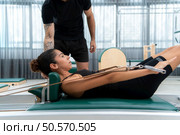 A young man and a young woman are doing pilates exercises on a pilates reformer. Стоковое фото, агентство Ingram Publishing / Фотобанк Лори