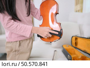 A girl violinist sets up and tunes a violin. Стоковое фото, агентство Ingram Publishing / Фотобанк Лори