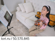A girl violinist sets up and tunes a violin. Стоковое фото, агентство Ingram Publishing / Фотобанк Лори