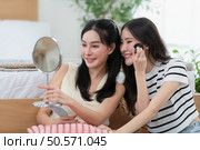 Asian young women conducting their weekly holiday routines from getting up, putting on cosmetics and relaxing. Стоковое фото, агентство Ingram Publishing / Фотобанк Лори