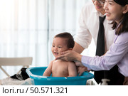 Father and mother bathe their son after they come home from work. Стоковое фото, агентство Ingram Publishing / Фотобанк Лори