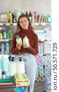 Uncertain young girl choosing convenient liquid hand soap in household goods shop. Стоковое видео, видеограф Яков Филимонов / Фотобанк Лори