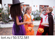 Children in ghost costumes are having fun trick-or-treating on Halloween. Стоковое фото, агентство Ingram Publishing / Фотобанк Лори