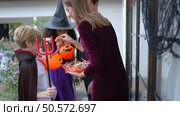 Children in ghost costumes are having fun trick-or-treating on Halloween. Стоковое фото, агентство Ingram Publishing / Фотобанк Лори